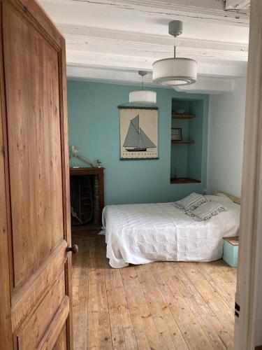 une chambre avec un lit et un mur bleu dans l'établissement Maison de vacances à Piriac-sur-mer à 800 m de la mer, à Piriac-sur-Mer