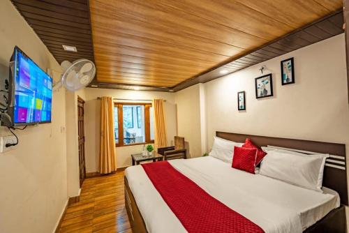 a bedroom with a large bed and a flat screen tv at Nainital Stays in Nainital