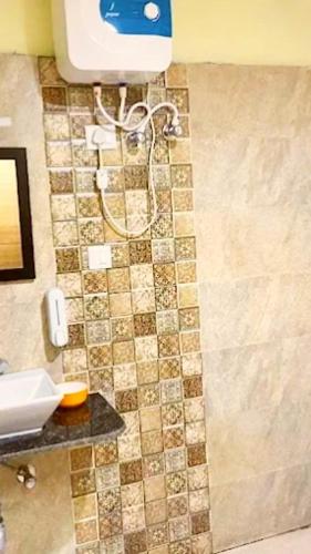 a bathroom with a shower with a phone on the wall at Alta Vista Resort in Joshīmath