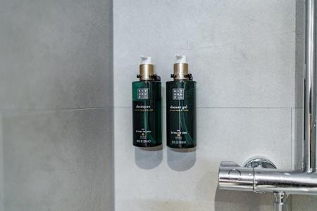 two green bottles ofodorizers on the wall of a bathroom at Martini Hotel in Groningen