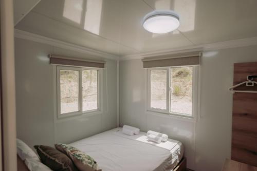a small room with a bed and two windows at Erato's Cottage in Plaka