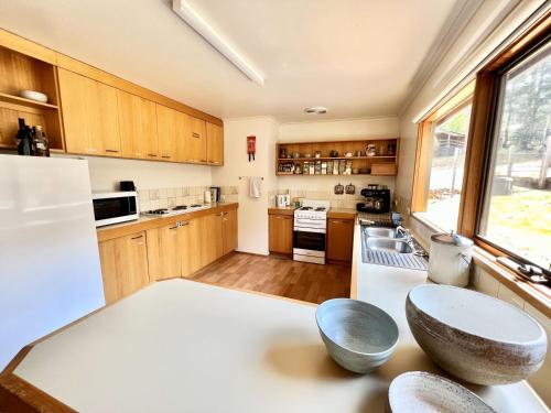 a kitchen with wooden cabinets and a white counter top at Albaski Lodge Room 2 in Mount Buller