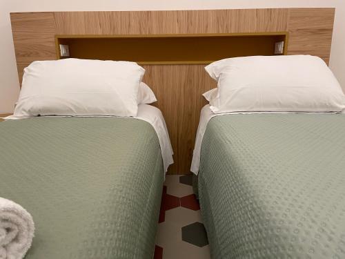 two beds sitting next to each other in a room at Il Genio - Residenza D'Epoca in Pisa
