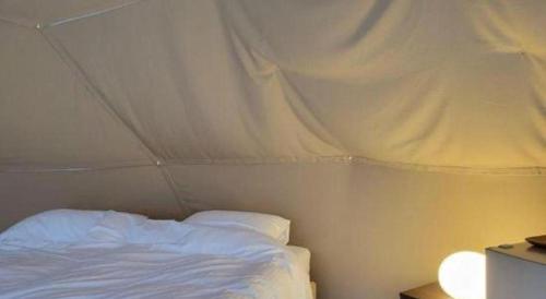 a bedroom with a white bed in a tent at Kyoto Keburikawa Hotel in Kameoka