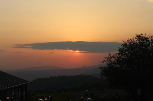 a sunset with the sun hiding behind a cloud at Billing View Camp and Mud Houses,Bir in Aiju
