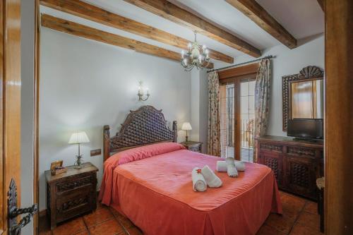 - une chambre dotée d'un lit rouge avec deux chaussures dans l'établissement Casa rural Las Eras de Riofrio, à Ríofrío