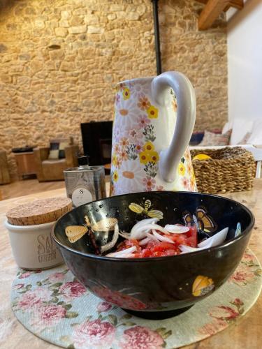 a bowl of food sitting on a table with a tea pot at La Casuca De la Iglesia in Ubiarco