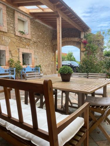 a wooden table and chairs on a patio at La Casuca De la Iglesia in Ubiarco