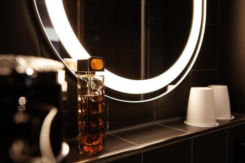 a bathroom with a mirror and a bottle on a counter at ibis Hotel Berlin Airport in Berlin