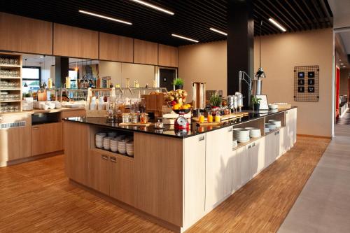 a large kitchen with a bar in a restaurant at ibis Hotel Berlin Airport in Berlin