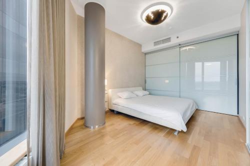 タリンにあるSkyResidence Amazing Luxury View Apartment HIGH23Fのベッドルーム(白いベッド1台、ポール付)