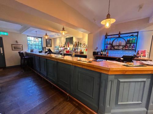 a bar in a pub with a wooden counter at OYO Blenheim House in Etwall