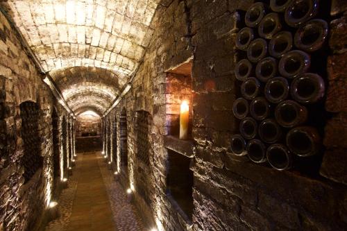 a tunnel in a wine cellar with wine barrels at Relais Castello di Razzano in Alfiano Natta