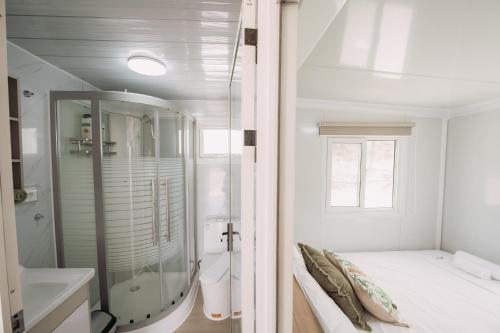 a bathroom with a shower and a bed and a sink at Erato's Cottage in Plaka