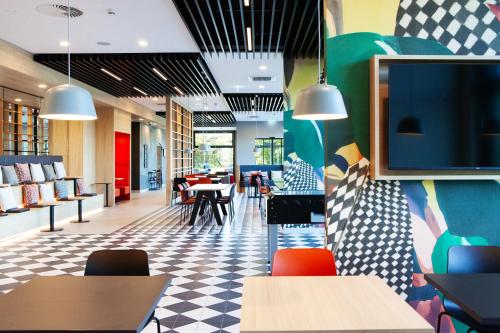 a dining room with a tv on the wall at ibis Hotel Berlin Airport in Berlin