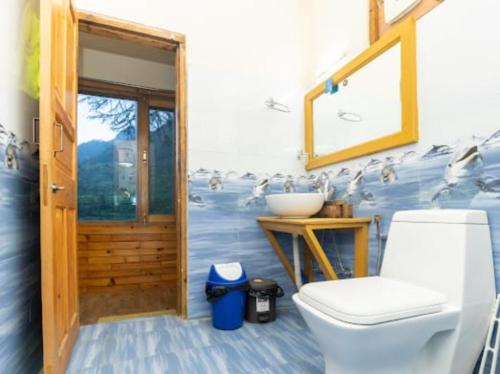 ein Badezimmer mit einem WC und einem Waschbecken mit Vögeln an der Wand in der Unterkunft Majestic View Cottages in Jibhi