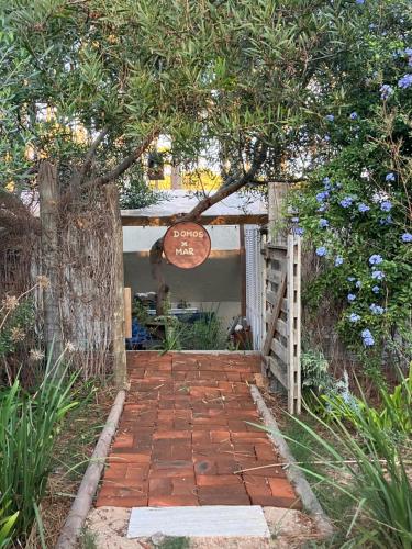 Una pasarela de ladrillos que conduce a una casa con un cartel. en DomosdeMar a 100 mts del mar, en Ocean Park