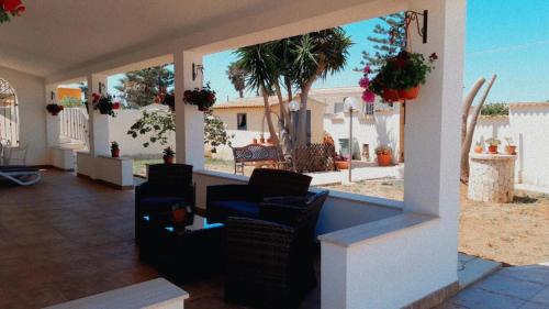 a porch with chairs and a view of a yard at Casa Marina Maltese via ucca marina SANTA MARIA DEL FOCALLO ISPICA in Santa Maria Del Focallo