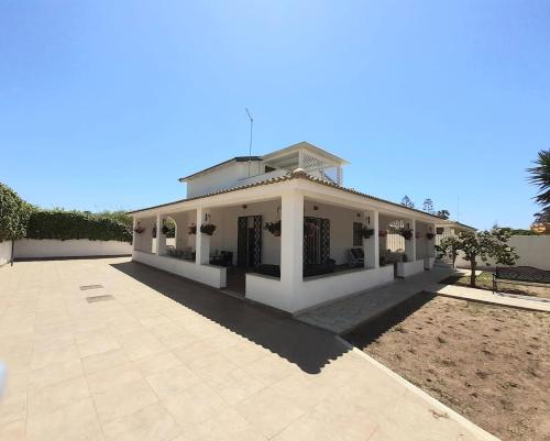 a large white house with a large driveway at Casa Marina Maltese via ucca marina SANTA MARIA DEL FOCALLO ISPICA in Santa Maria Del Focallo