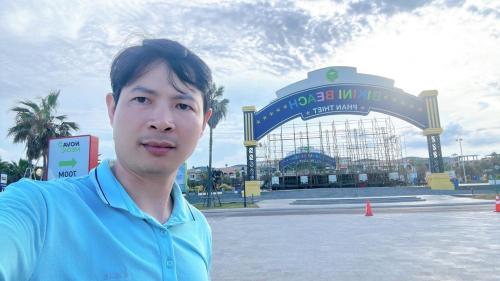 un homme en chemise bleue debout devant une porte dans l'établissement Villa Luxury Novaworld Phan Thiết nghỉ dưỡng thượng lưu giữa biển xanh tuyệt đẹp, à Bình Tú