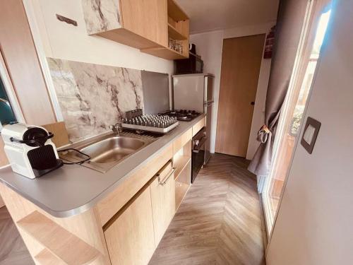 une petite cuisine avec un évier et une cuisinière dans l'établissement Mobil Home Jasmins 3, à Valras-Plage