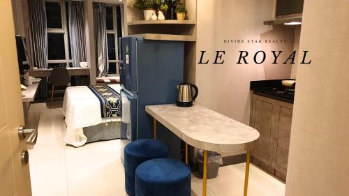 a kitchen with a table and blue stools in a room at Le Royal Benson Apartment at Supermal Pakuwon in Surabaya
