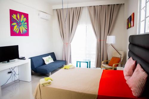 a bedroom with a bed and a couch and a tv at Art Villa Dominicana in Punta Cana