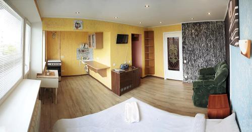 a living room with a bed and a living room with yellow walls at Apartament Erfolg 3 in Daugavpils