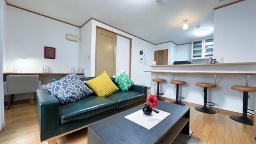 a living room with a couch and a bar at 駅徒歩1分 観光拠点に最適なゆったり快適一軒家 in Osaka