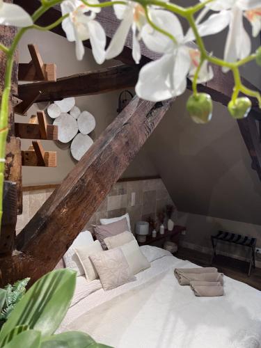 a bed with white sheets and pillows in a room at La 104 Zen Suite romantique dans maison réservée aux hôtes in Saint-Omer