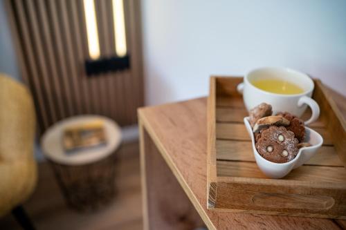 a table with a cup of tea and a bowl of cookies at Apartment under the Larch in Jesenice
