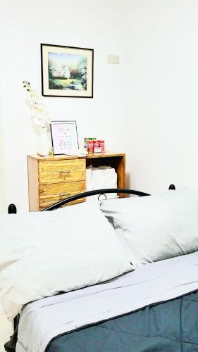 a bedroom with a bed and a desk with a laptop at B Guest House Room Rentals in San Fernando