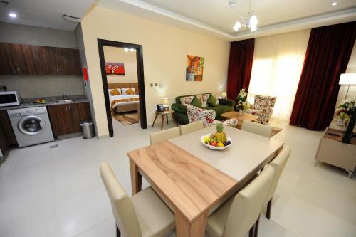 a dining room and living room with a table and chairs at Al Mansour Park Inn Hotel&Apartment in Doha