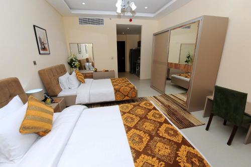 a hotel room with two beds and a mirror at Al Mansour Park Inn Hotel&Apartment in Doha