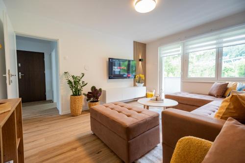 a living room with a couch and a table at Apartment under the Larch in Jesenice