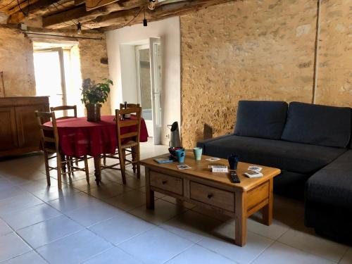 un salon avec un canapé et une table dans l'établissement L'Escaleyrou, gîte familial, charme & confort pour un séjour à côté de Lascaux, à Aubas