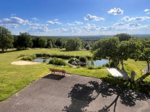 un banc installé dans un parc à côté d'un étang dans l'établissement Vue exceptionnel-Piscine chauffée-salle de sport, à Saint-Jean-de Laurs