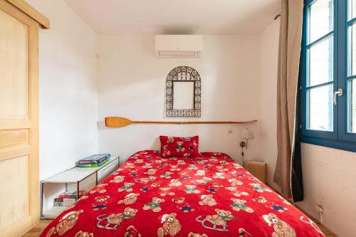 - une chambre avec un lit rouge et une couette rouge dans l'établissement Le Chalet des Eucalyptus - à 200 m de la plage, à Fleury