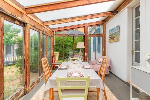 une salle à manger avec une table et des chaises dans l'établissement Le Chalet des Eucalyptus - à 200 m de la plage, à Fleury
