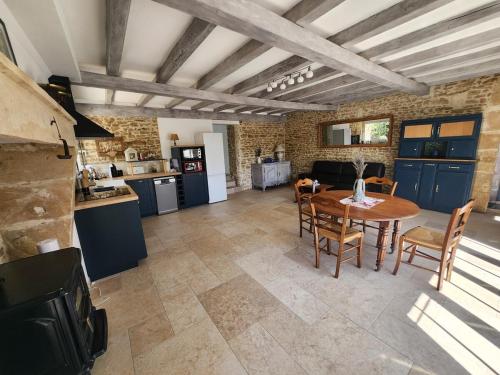 une cuisine et un salon avec une table et des chaises dans l'établissement La Petite Maison d Exireuil, à La Celle-sous-Gouzon