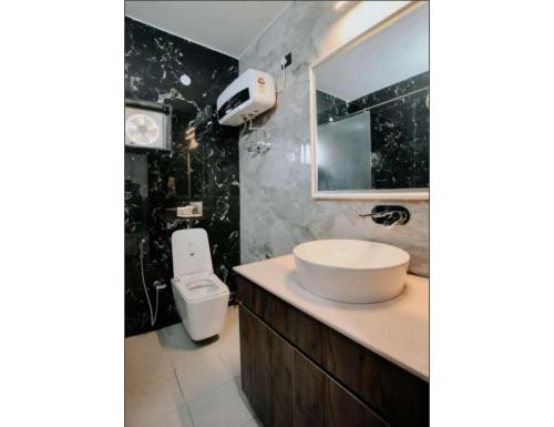 Un baño con lavabo, inodoro y espejo. en Vantara Luxe Villa Entire 2 BHK Apartment, en Bhimtal