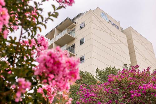 a building with pink flowers in front of it at Hume Serviced Apartments in Adelaide