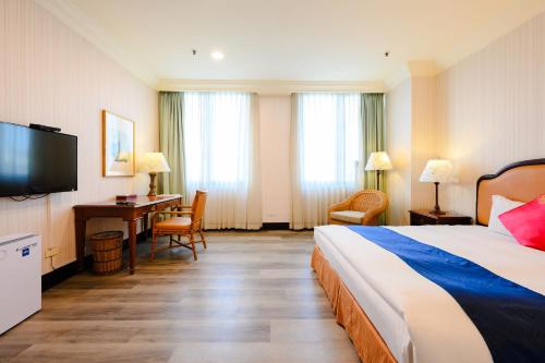 Postel nebo postele na pokoji v ubytování Wei-Yat Grand Hotel