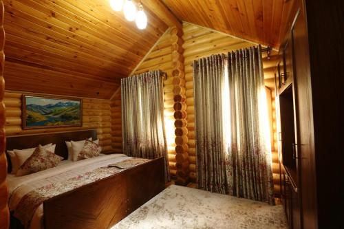 a bedroom with a bed in a wooden cabin at Sherwood Resort in Bulaksu