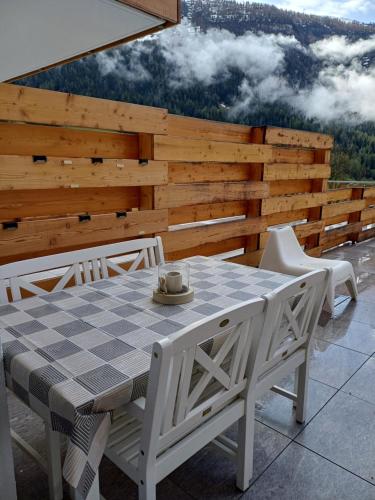 a table and chairs on a patio with a view at Spacieux appart - 2 chambres à coucher incl Jacuzzi Privé in Leukerbad