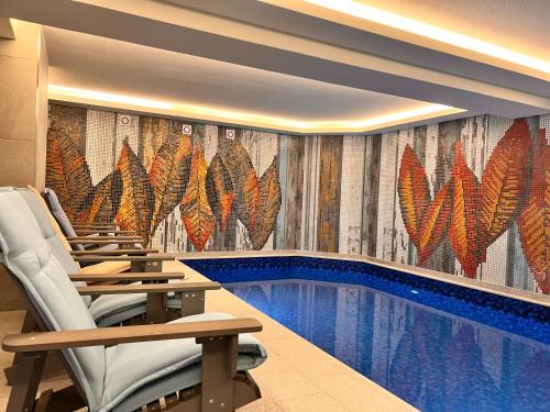 サルニトゥサにあるArdo Hill Spa Hotel and Restaurantのホテルの部屋にあるプールとその横に椅子