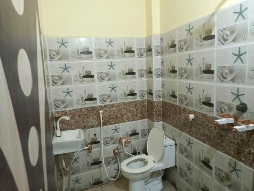 a bathroom with a toilet and a sink at Hotel Shivoham in Mathura