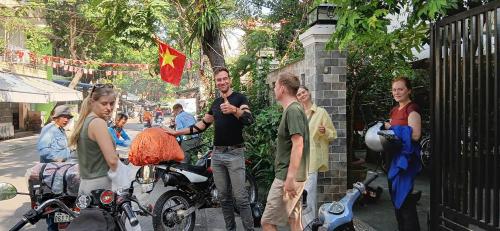 a group of people standing around a gate with a flag at Quynh Long Villa in Hoi An