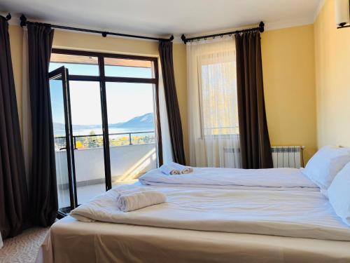 サルニトゥサにあるArdo Hill Spa Hotel and Restaurantの大きなベッドと大きな窓のある寝室