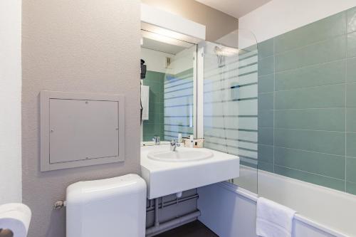 a bathroom with a sink and a toilet and a mirror at Appart'City Classic Lyon Part Dieu Villette in Lyon